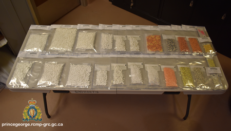 Photo de comprimés sur ordonnance saisis lors d’une enquête. Les comprimés sont disposés sur une table dans des sacs pour pièces à conviction individuels.
