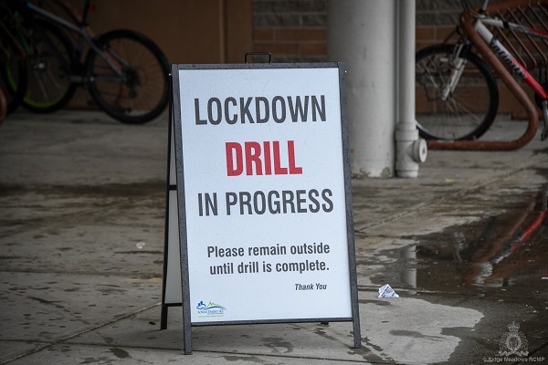 A sign outside a school that reads "Lockdown Drill in Progress"