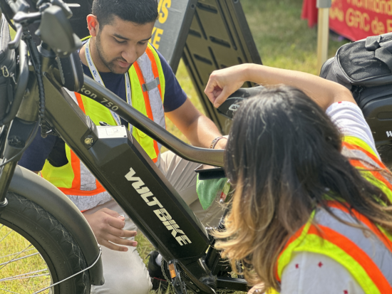 two volunteers inspecting an electric bike 