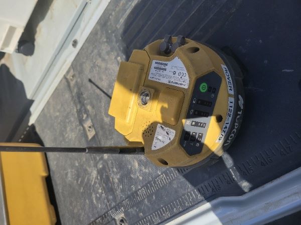 A round yellow Topcon device with antenna. 