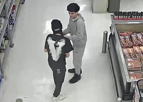 The back of suspect 2 talking to suspect one inside the store