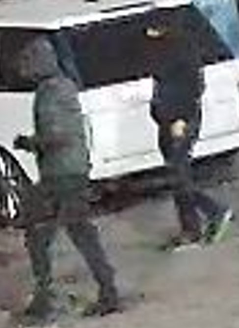 Photo of two individuals walking, both wearing dark clothing and their faces are not visible.