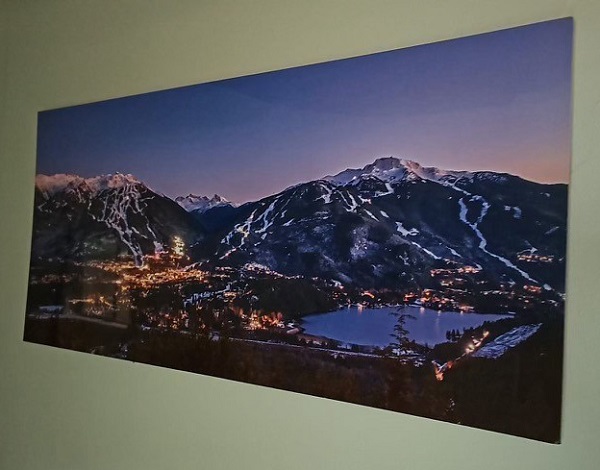 Photograph of stolen art which shows snowy mountains with ski runs at dusk