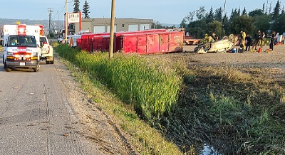 Photo de la scène de la collision avec l’ambulance à gauche et la voiture blanche renversée à droite.