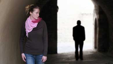 Person walking with a black silhouette of another person behind them