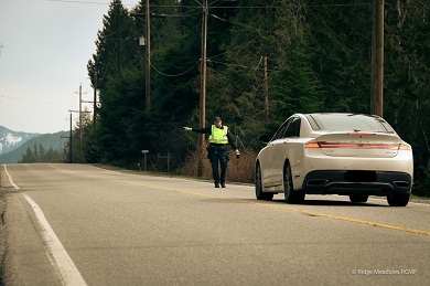 Photo of police officer stopping a White car which was speeding