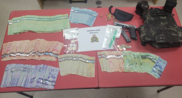 Photo of money in various denominations a handgun, ammunition and body armor