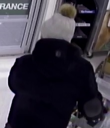 CCTV photo of the back of the suspect showing a high jacket collar and grey toque
