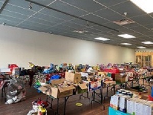 Photo of several tables in a large room with serval items that were donated.