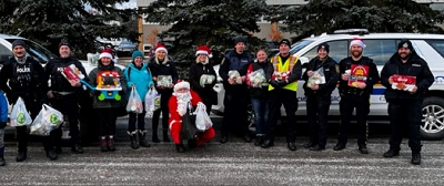 RCMP and Volunteers in front of police vehicles with donations