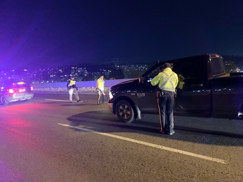 Police officer speak with driver of a black truck during Light up the Highway Campaign