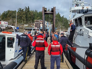 RCMP and Canadian Coast Guard on a dock with youth