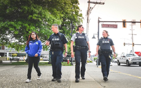 Street in downtown Maple Ridge with police, bylaw officers and volunteers walking.