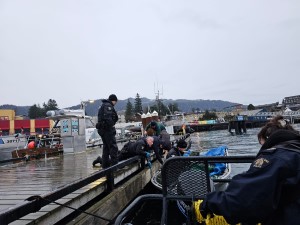 Prince Rupert RCMP and West Coast Marine Members tie up a boat to dock in Cow Bay Marina